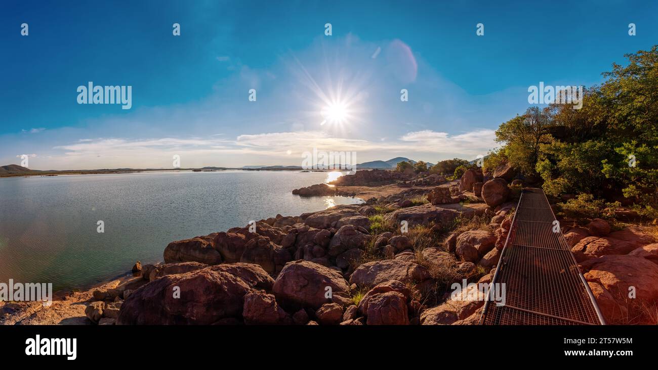 lac au coucher du soleil, pont métallique sur les rochers, près de gaborone capitale du Botswana, paysages africains, vue surélevée depuis l'île en fin d'après-midi Banque D'Images