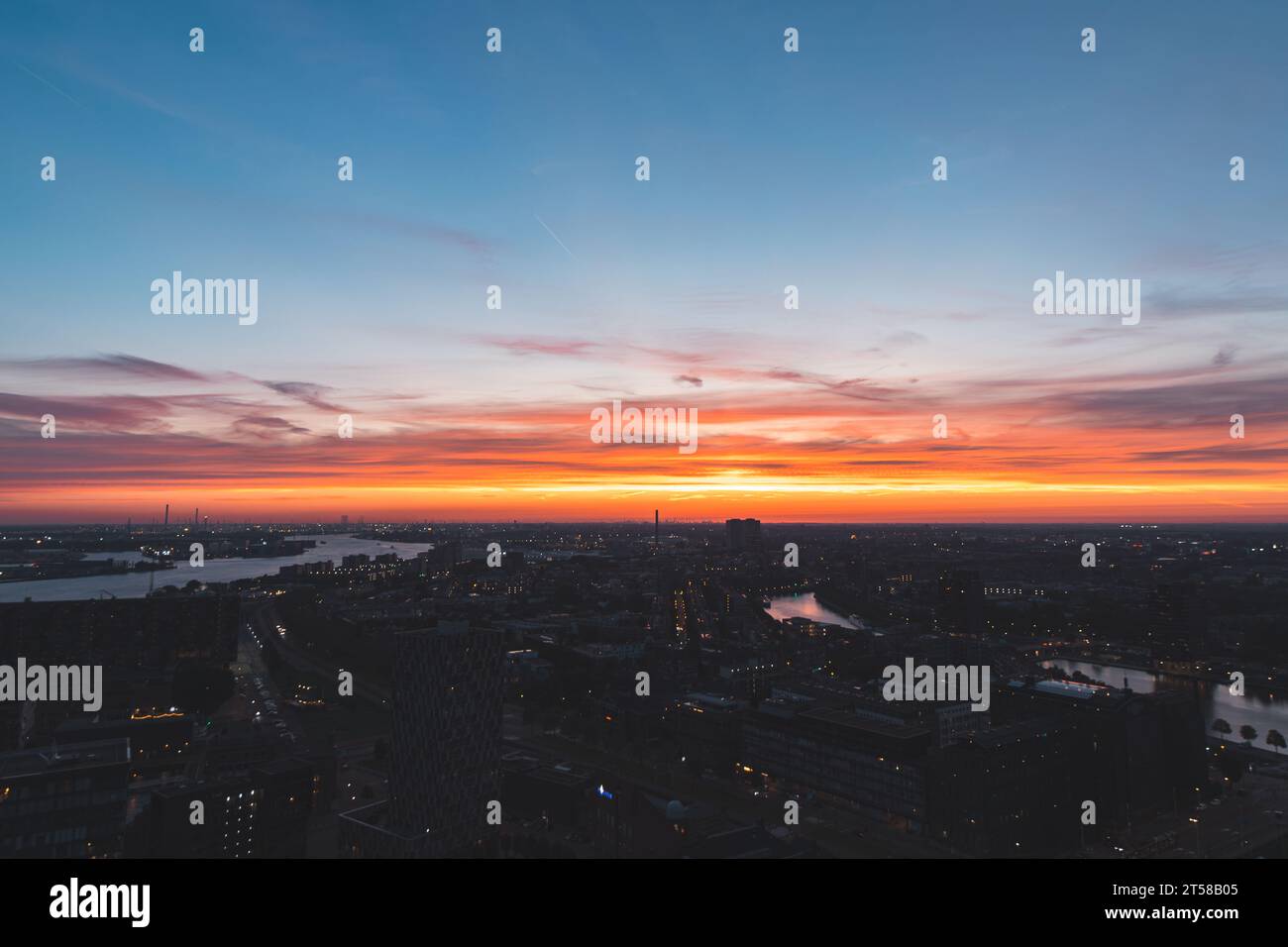 Vue aérienne de la vie nocturne dans la ville moderne de Rotterdam aux pays-Bas. Lueur rouge du soleil couchant en arrière-plan. Banque D'Images