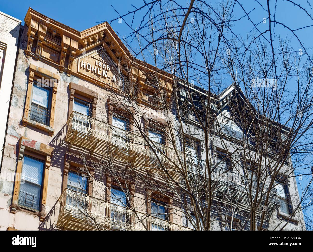 Les 249 et 251 East 77th Street sont des immeubles d'appartements en grès brun jumelé miroir de cinq étages avec des magasins au rez-de-chaussée dans l'Upper East Side. Banque D'Images