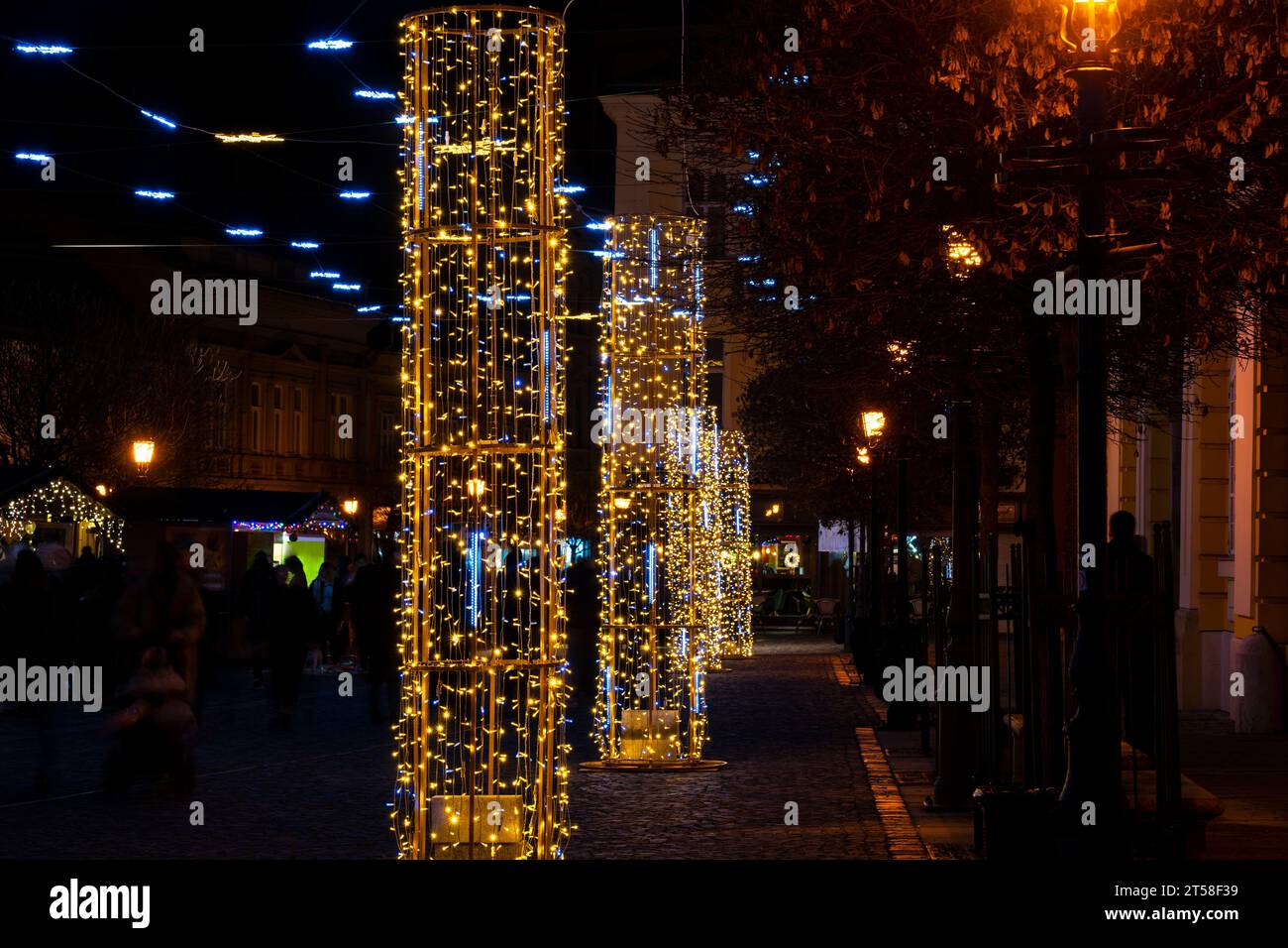 Lumières de noël colorées avec des lampadaires brouillés en arrière-plan la nuit Banque D'Images