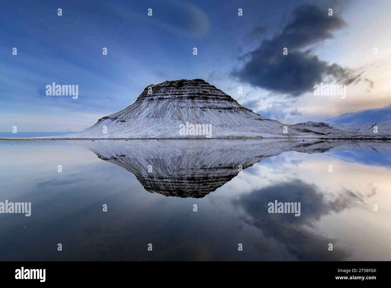 Kirkjufell, nunatak colline couverte de neige reflétée dans l'eau du fjord sur la péninsule de Snæfellsnes en hiver, montagne la plus photographiée en Islande Banque D'Images