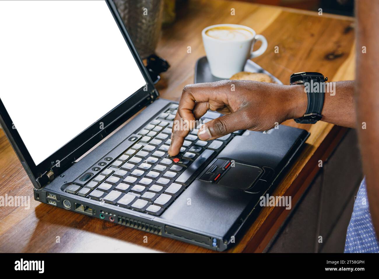 Gros plan de la main d'un homme noir méconnaissable debout travaillant à taper sur un ordinateur portable au-dessus du bar à l'intérieur du restaurant, concept de technologie, espace de copie. Banque D'Images