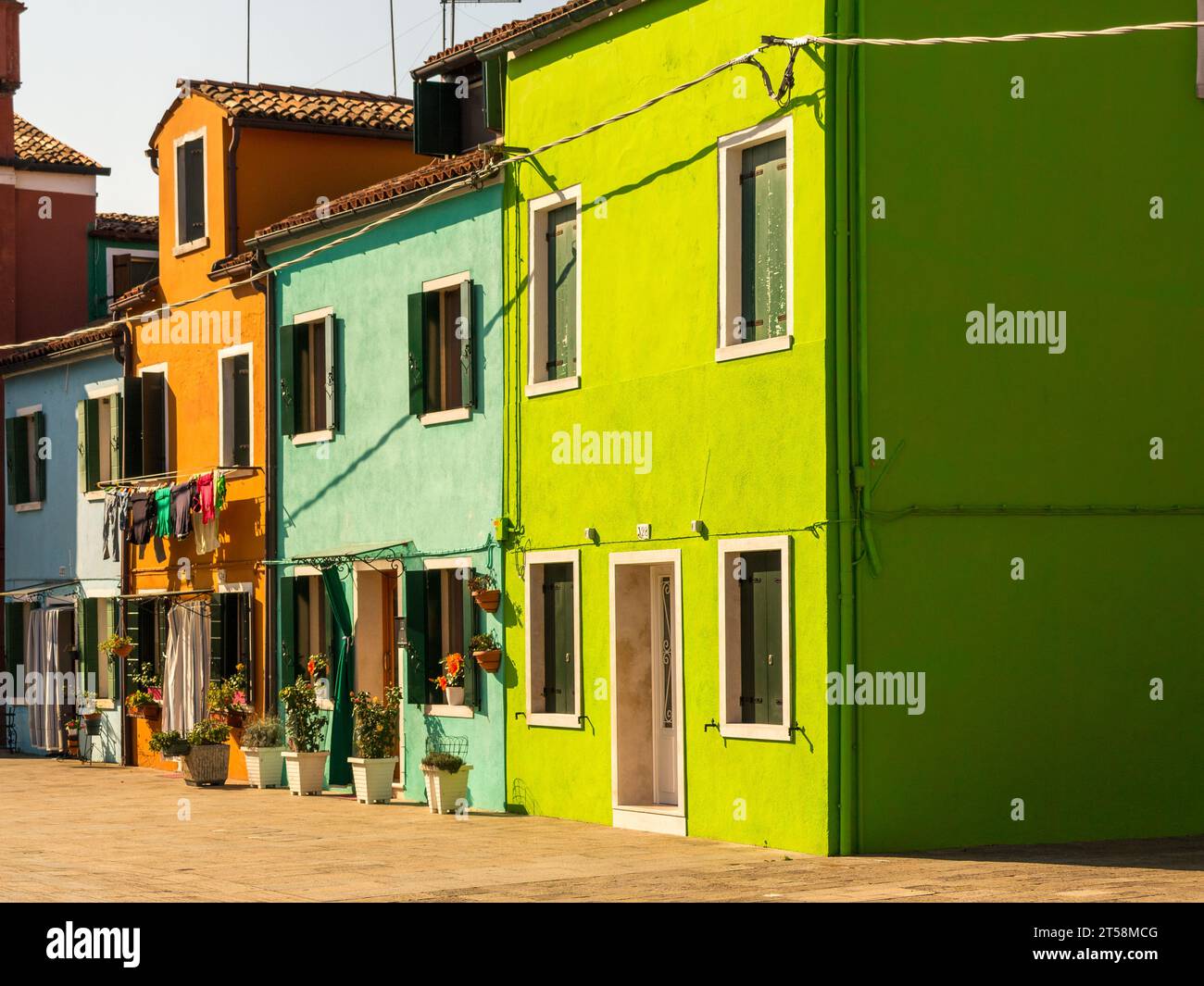 Maisons de Burano, Venise, Italie. La couleur verte domine. Nous voyons aussi des maisons en bleu pâle et couleurs Sienna. Banque D'Images