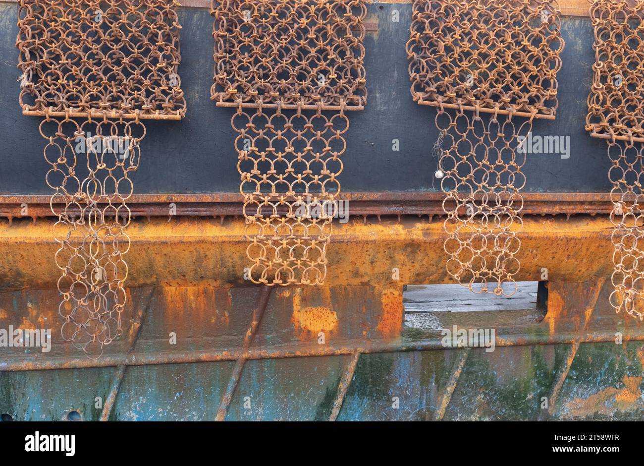 Vue rapprochée des dragues de pétoncles sur le côté d'un bateau de pêche au pétoncle amarré au port de Kirkcudbright, en Écosse. Banque D'Images