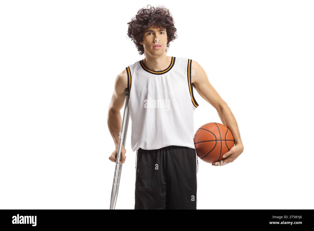 Joueur de basket tenant une balle et s'appuyant sur une béquille isolée sur fond blanc Banque D'Images