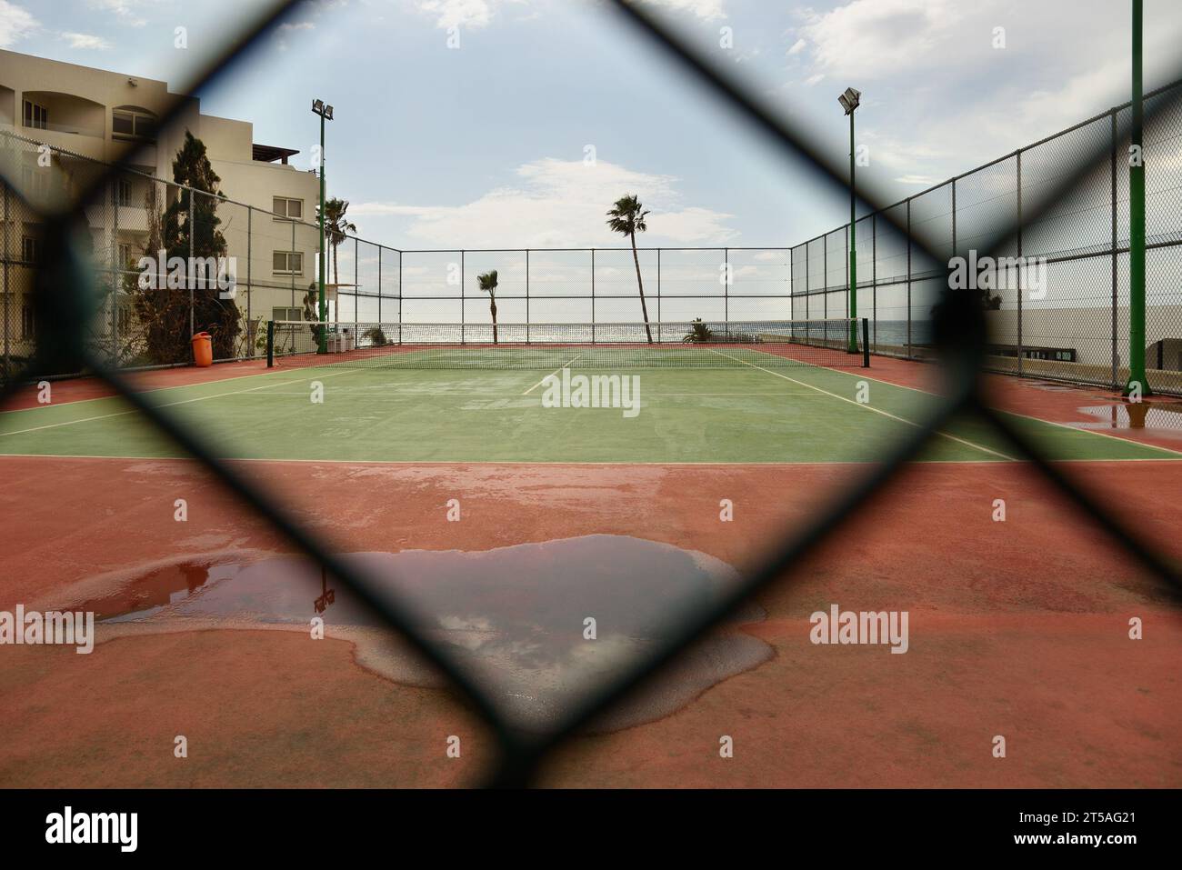 Un stade avec une flaque d'eau à travers une clôture métallique. Banque D'Images Un stade avec une flaque d'eau à travers une clôture métallique. Banque D'Images