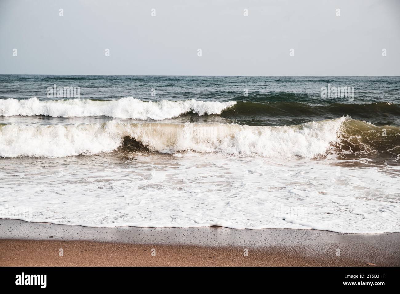 Vue sur les vagues de la mer sur une plage avec mousse massive, fond de nature. Banque D'Images