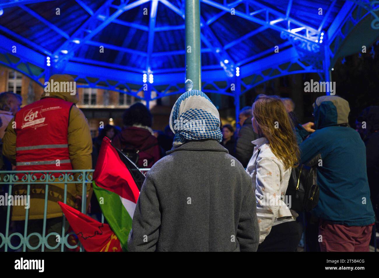 Montauban, France. 04 novembre 2023. Parlant, des gens de derrière avec un drapeau palestinien. Procession aux flambeaux dans les rues centrales de Montauban et la place nationale pour appeler à l arrêt immédiat de l offensive militaire israélienne contre la bande de Gaza. Arrêtez le massacre à Gaza ! Cessez-le-feu immédiat, appelé par AFPS 82, CGT, solidaires, FSU, PC, NPA, LFI, ATTAC, RESF, LDH. France, Toulouse 3 novembre 2023. Photographie de Patricia Huchot-Boissier /ABACAPRESS.COM crédit : Abaca Press/Alamy Live News Banque D'Images