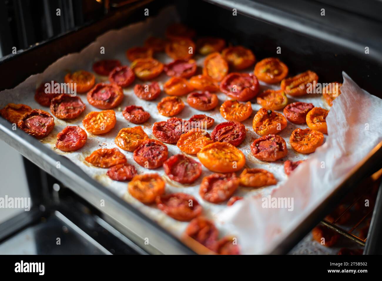 Cuisson des tomates séchées au soleil dans le four de la cuisine Banque D'Images