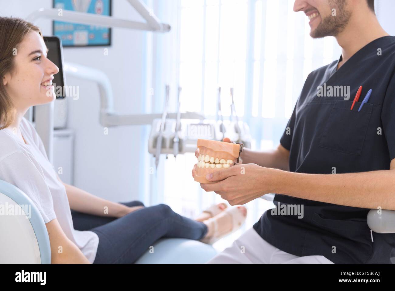 Gros plan dentiste masculin montrant le patient modèle de dents Banque D'Images