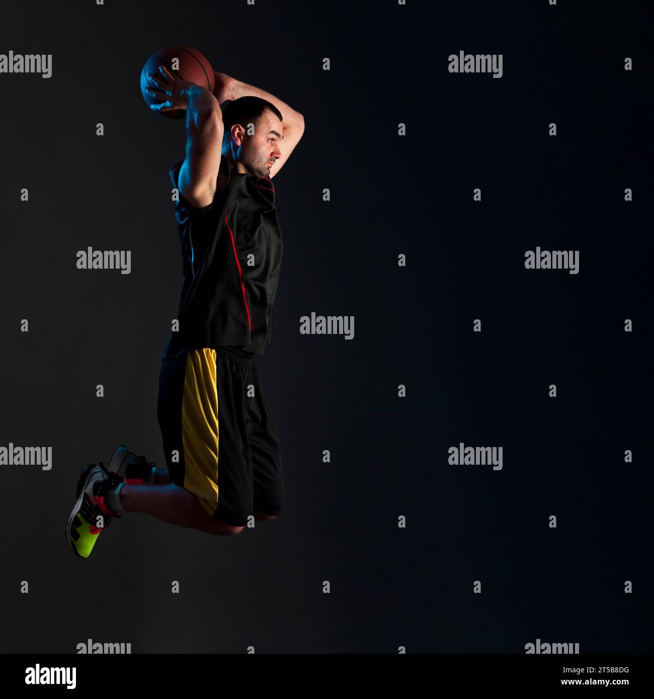 Vue latérale joueur de basket-ball dunking avec espace de copie Banque D'Images