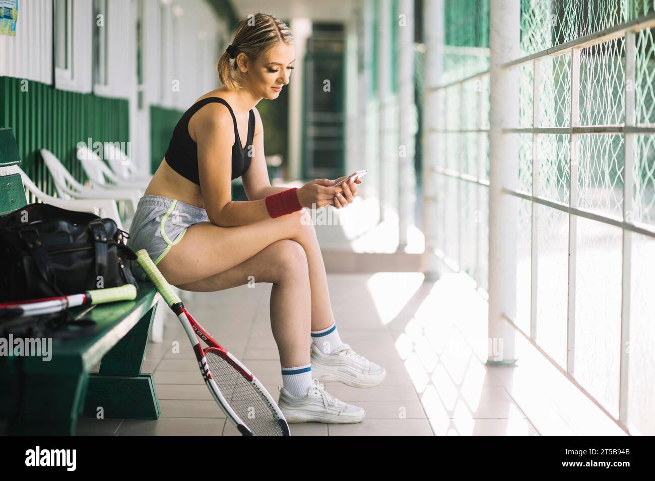 Femme joueuse de tennis vérifiant son téléphone Banque D'Images