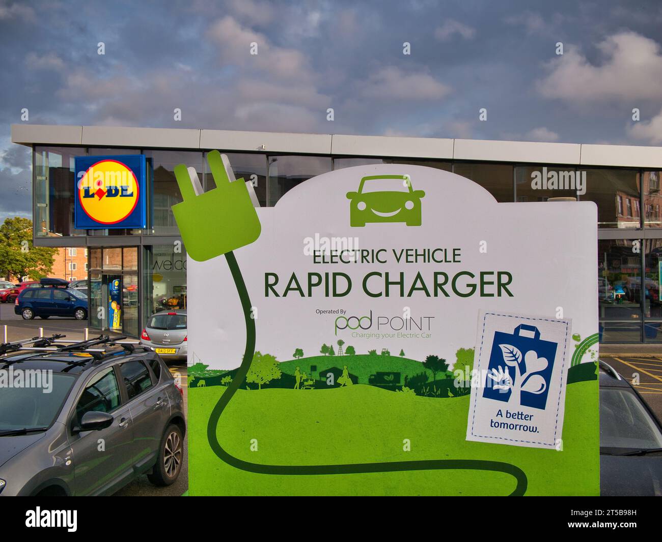 Signalisation visible sur un point de recharge rapide de véhicules électriques dans un parking client dans une succursale du supermarché de discount allemand, Lidl. Banque D'Images