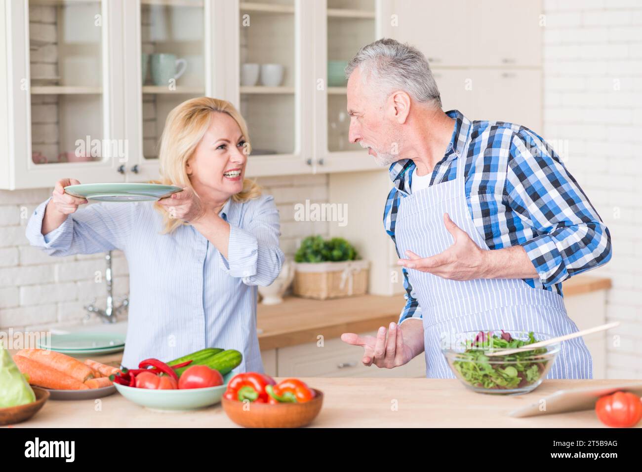 Couple senior en colère se battant avec l'autre cuisine Banque D'Images
