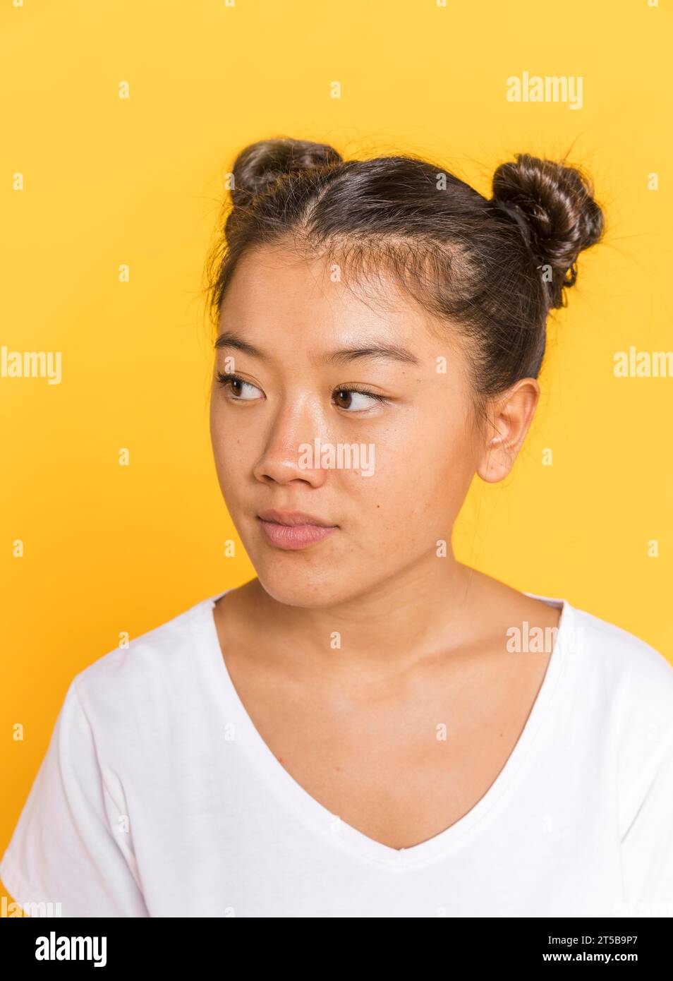 Gros plan femme avec les cheveux attachés regardant loin Banque D'Images