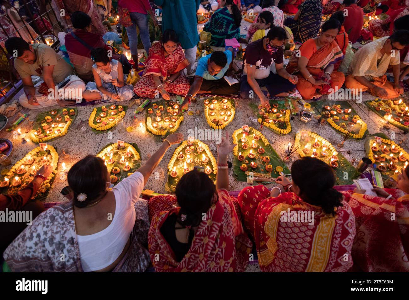 Dhaka, Bangladesh. 4 novembre 2023. Les dévots hindous s'assoient avec Prodip (lumières) et prient Dieu pour le bien-être de la famille devant le temple Shri Shri Lokanath Brahmachari Ashram, Swamibag, Dhaka pendant le Kartik Brati ou Rakher Upobash, un festival religieux hindou de jeûne organisé chaque année à la dernière moitié du mois bengali Kartik. Les dévots s'assoient avec de la nourriture et des bougies et prient sincèrement le Dieu avant de rompre le jeûne. Lokenath Brahmachari qui est appelé Baba Lokenath était un saint hindou du 18e siècle et philosophe au Bengale. Les dévots de Lokenath Brahmachari prient avec lumière pour sauver leur famille Banque D'Images