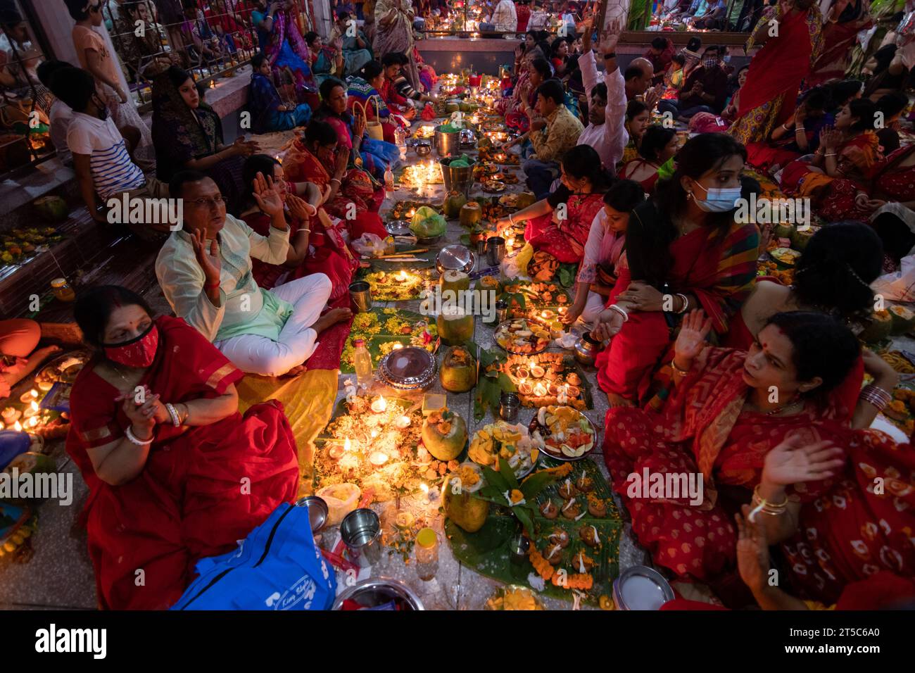 Dhaka, Bangladesh. 4 novembre 2023. Les dévots hindous s'assoient avec Prodip (lumières) et prient Dieu pour le bien-être de la famille devant le temple Shri Shri Lokanath Brahmachari Ashram, Swamibag, Dhaka pendant le Kartik Brati ou Rakher Upobash, un festival religieux hindou de jeûne organisé chaque année à la dernière moitié du mois bengali Kartik. Les dévots s'assoient avec de la nourriture et des bougies et prient sincèrement le Dieu avant de rompre le jeûne. Lokenath Brahmachari qui est appelé Baba Lokenath était un saint hindou du 18e siècle et philosophe au Bengale. Les dévots de Lokenath Brahmachari prient avec lumière pour sauver leur famille Banque D'Images