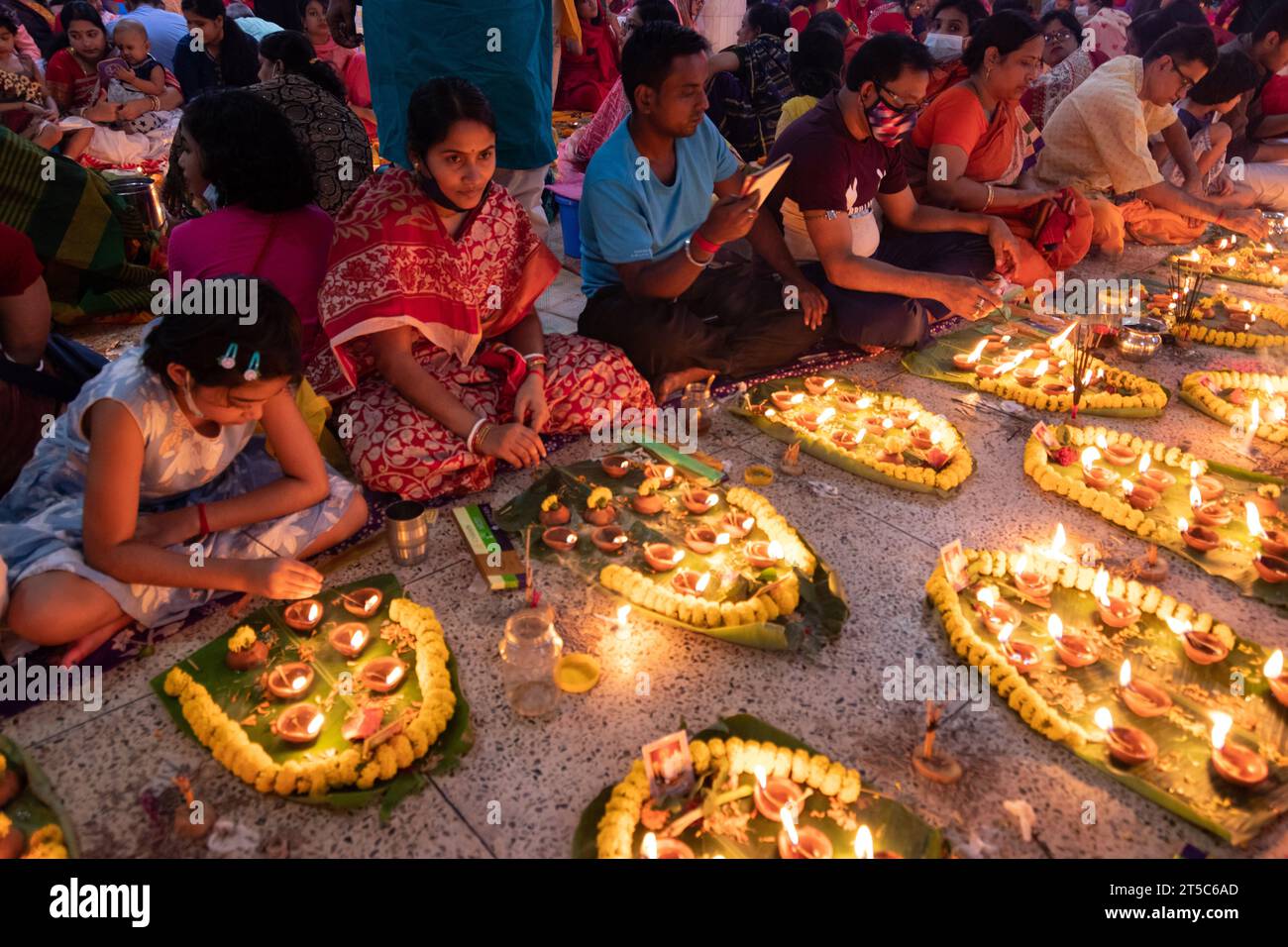 Dhaka, Bangladesh. 4 novembre 2023. Les dévots hindous s'assoient avec Prodip (lumières) et prient Dieu pour le bien-être de la famille devant le temple Shri Shri Lokanath Brahmachari Ashram, Swamibag, Dhaka pendant le Kartik Brati ou Rakher Upobash, un festival religieux hindou de jeûne organisé chaque année à la dernière moitié du mois bengali Kartik. Les dévots s'assoient avec de la nourriture et des bougies et prient sincèrement le Dieu avant de rompre le jeûne. Lokenath Brahmachari qui est appelé Baba Lokenath était un saint hindou du 18e siècle et philosophe au Bengale. Les dévots de Lokenath Brahmachari prient avec lumière pour sauver leur famille Banque D'Images