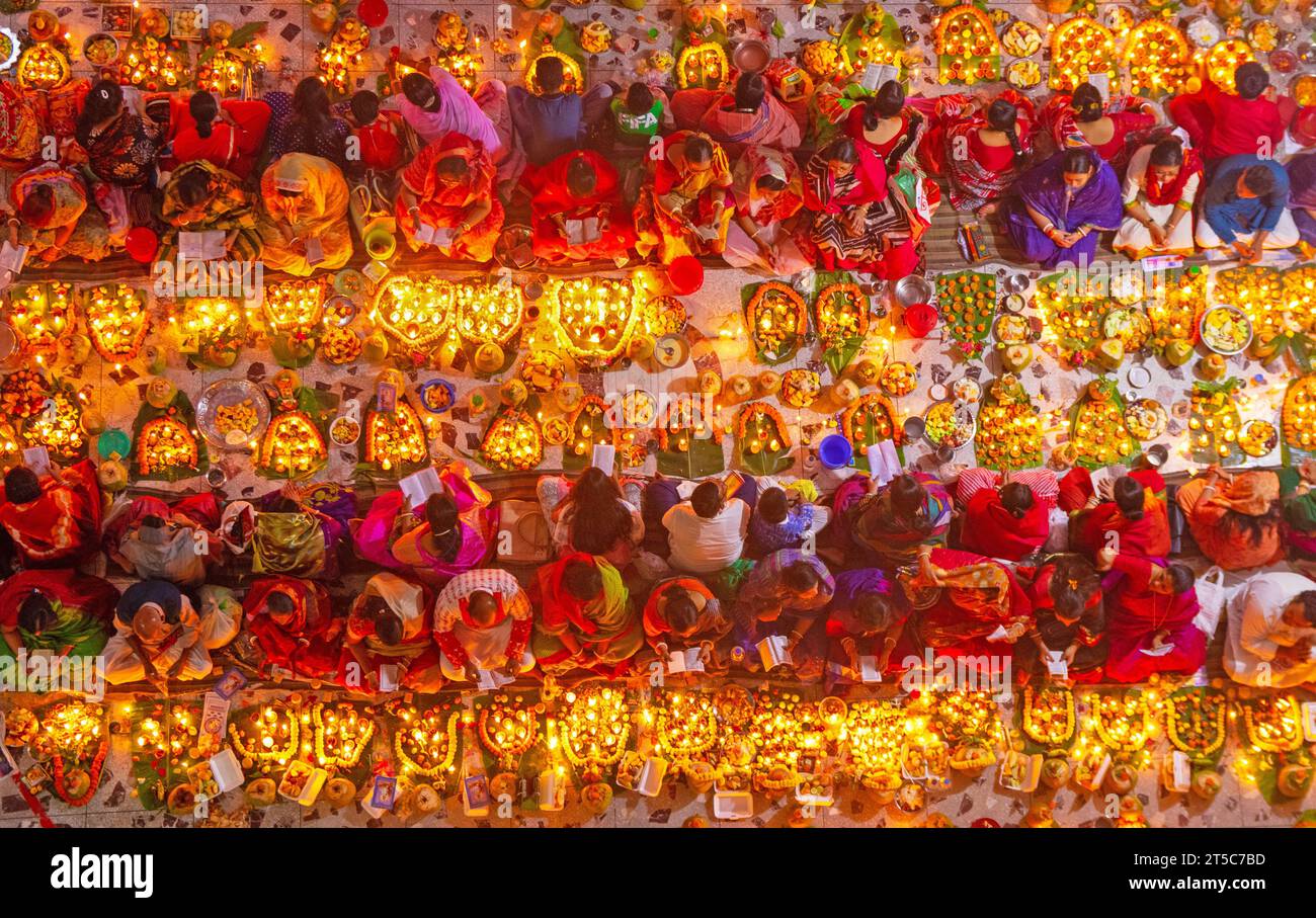 Dhaka, Bangladesh. 4 novembre 2023. Les dévots hindous s'assoient avec Prodip (lumières) et prient Dieu pour le bien-être de la famille devant le temple Shri Shri Lokanath Brahmachari Ashram, Swamibag, Dhaka pendant le Kartik Brati ou Rakher Upobash, un festival religieux hindou de jeûne organisé chaque année à la dernière moitié du mois bengali Kartik. Les dévots s'assoient avec de la nourriture et des bougies et prient sincèrement le Dieu avant de rompre le jeûne. Lokenath Brahmachari qui est appelé Baba Lokenath était un saint hindou du 18e siècle et philosophe au Bengale. Les dévots de Lokenath Brahmachari prient avec lumière pour sauver leur famille Banque D'Images