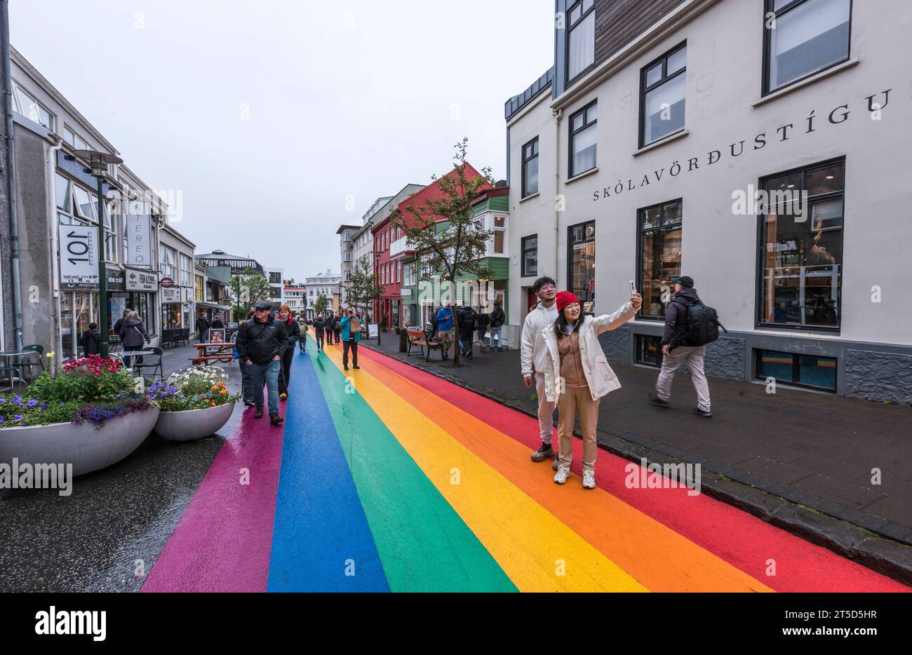 REYKJAVIK, ISLANDE - 26 AOÛT 2023 : des touristes avec smartphone prennent un selfie à Rainbow Street Banque D'Images