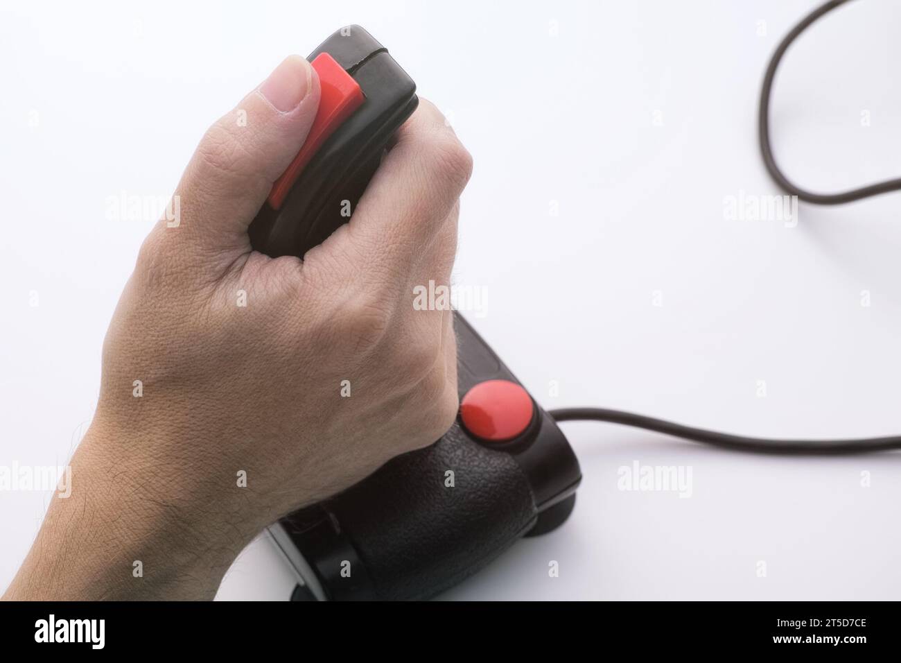 Un homme jouant à un jeu vidéo avec un joystick rétro. Joystick de jeu du milieu des années 1980 Banque D'Images