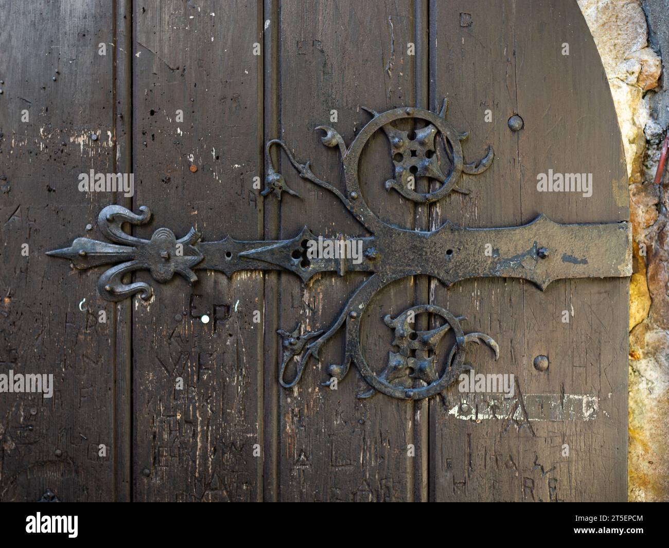 Gros plan d'une porte médiévale en bois avec des éléments en acier forgé. Le design décoratif antique a des formes d'ornement et appartient à un vieux château. Banque D'Images