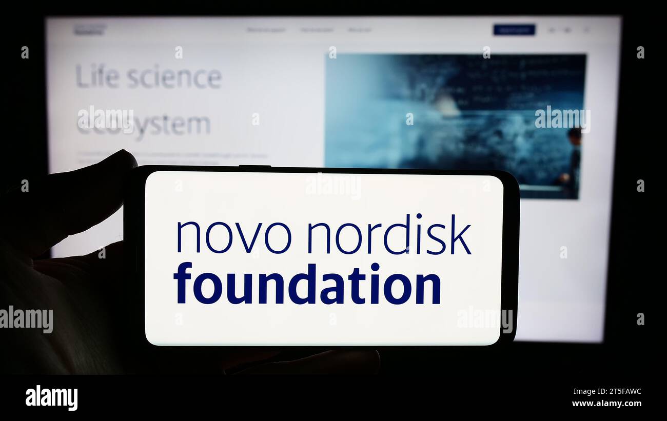 Personne détenant un smartphone avec le logo de l'organisation danoise Novo Nordisk Foundation devant le site Web. Concentrez-vous sur l'affichage du téléphone. Banque D'Images
