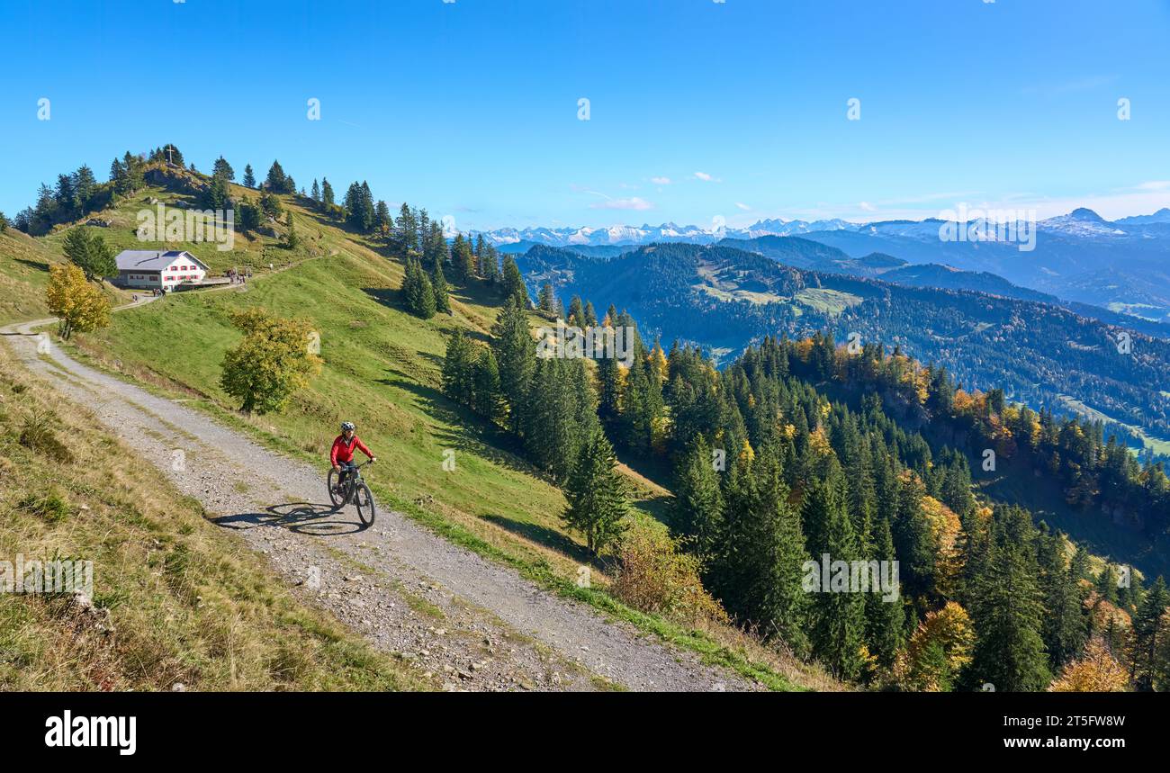 Jolie femme senior faisant du vélo de montagne électrique en automne et profitant de la vue spectaculaire sur les alpes de la forêt d'Allgau et de Bregenz près de Steibis Banque D'Images
