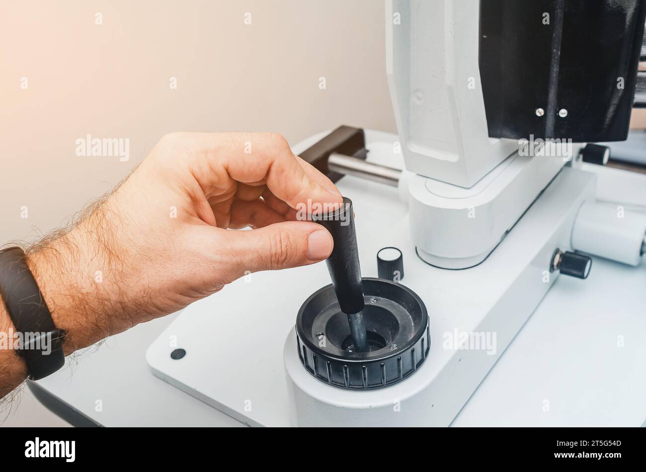 La main de l'homme tient la poignée de l'appareil. Dispositif ophtalmologique moderne. Banque D'Images