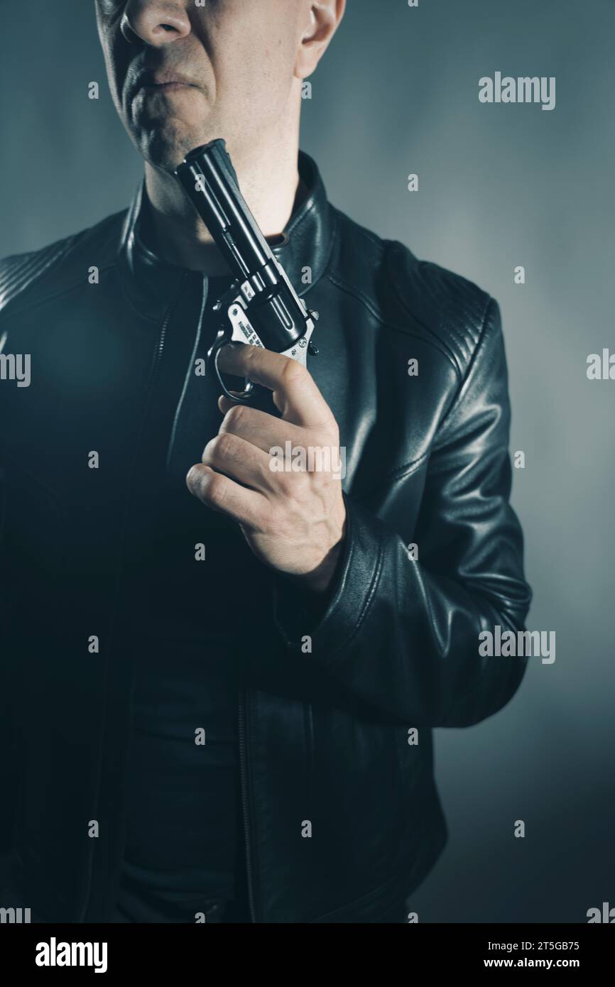 Veste en cuir noir hitman détective espion meurtrier assasin avec photo de portrait d'arme à feu. Banque D'Images