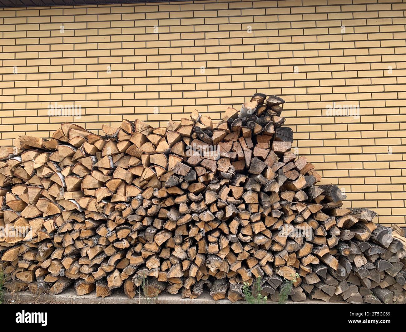 Grande pile d'un bois de chauffage. Près de la maison de brique Banque D'Images