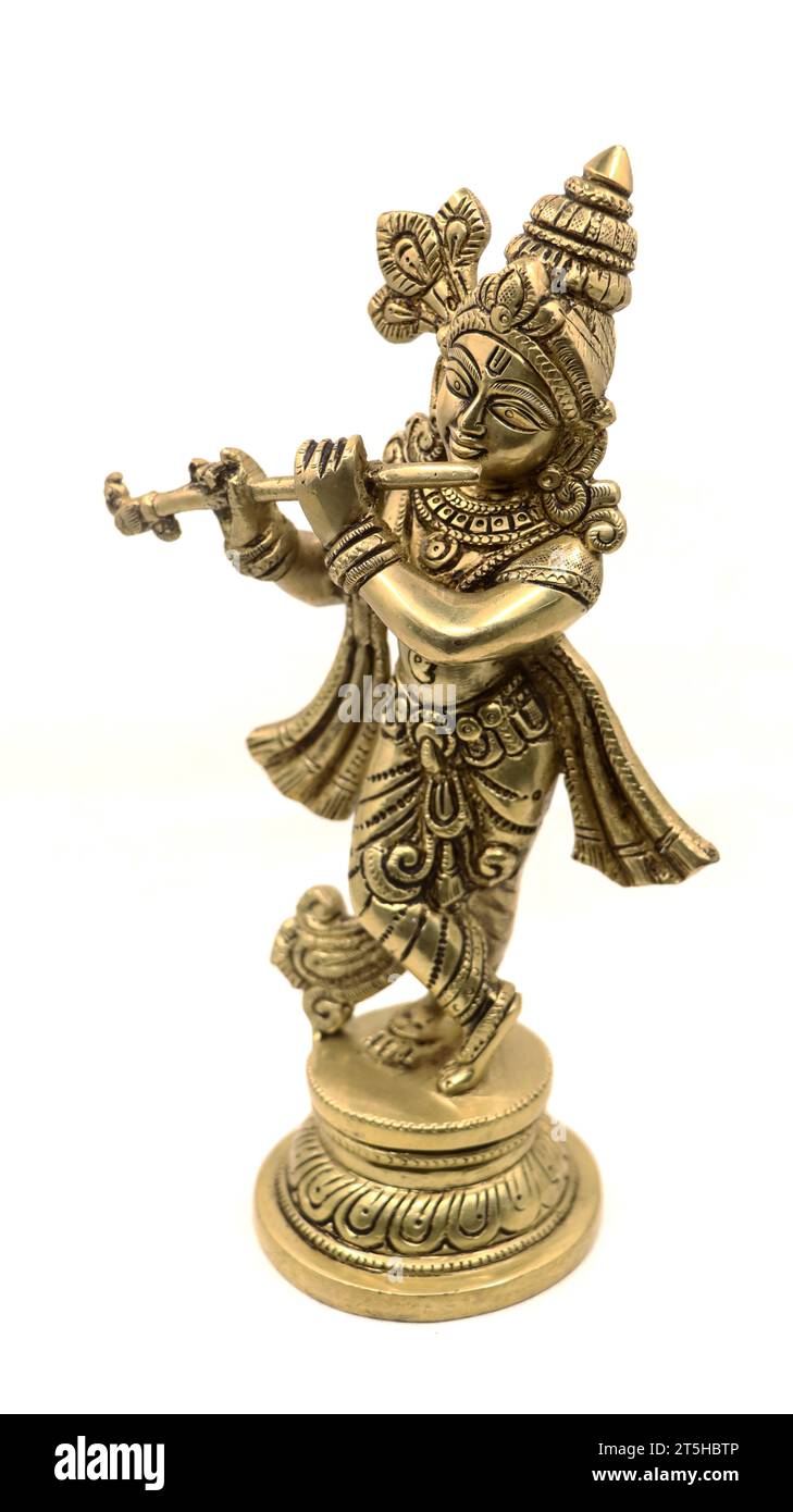 statue en laiton doré du dieu hindou lord krishna dans une tenue rurale jouant de la flûte isolée dans un fond blanc Banque D'Images