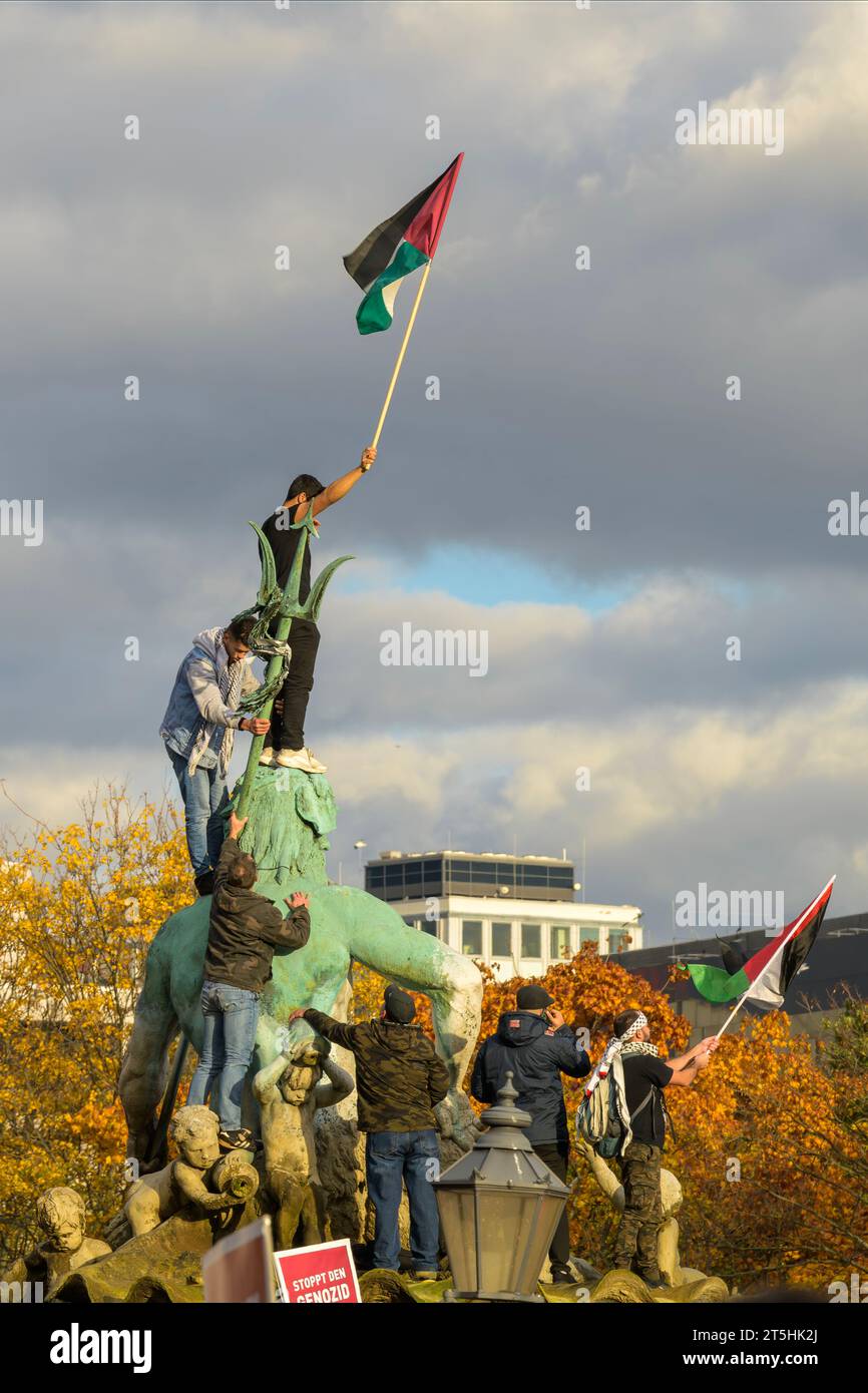 Allemagne , Berlin , 04.11.2023 , les manifestants grimpent à la fontaine de Neptune à Berlin sans permission et agitent le drapeau palestinien Banque D'Images