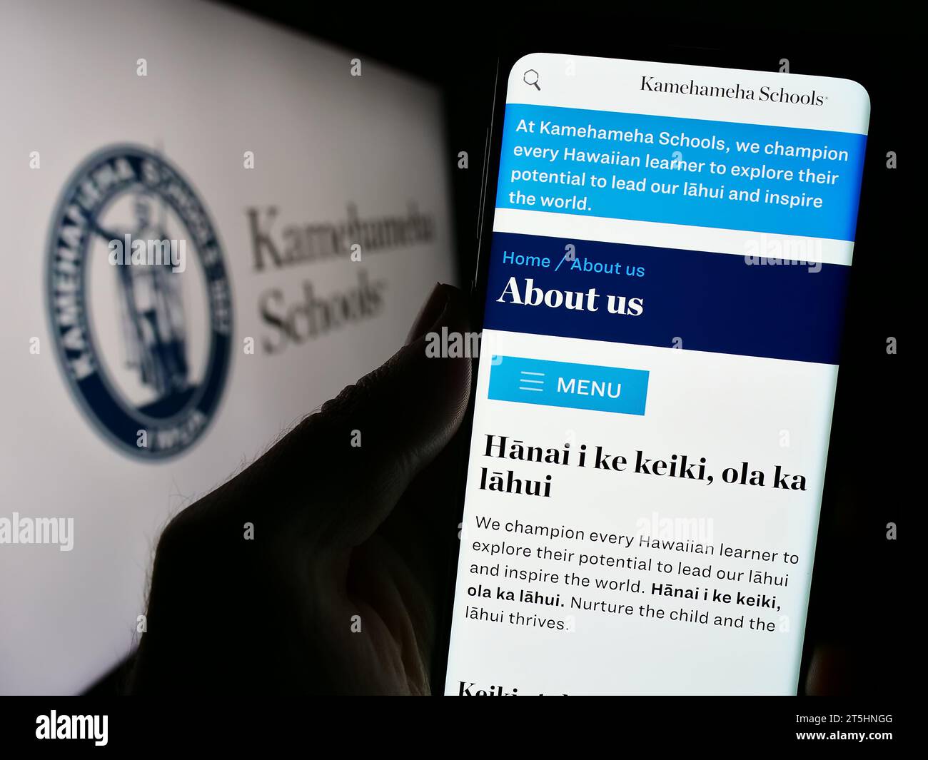 Personne tenant un smartphone avec une page Web de l'organisation d'éducation privée hawaïenne Kamehameha Schools avec logo. Concentrez-vous sur le centre de l'écran du téléphone. Banque D'Images