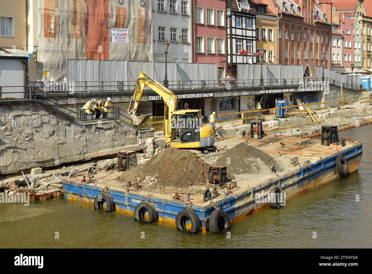 Travaux de rénovation et chantier avec excavatrice sur plate-forme flottante sur la promenade de la rivière Motlawa dans la vieille ville de Gdansk, Pologne, Europe UE Banque D'Images