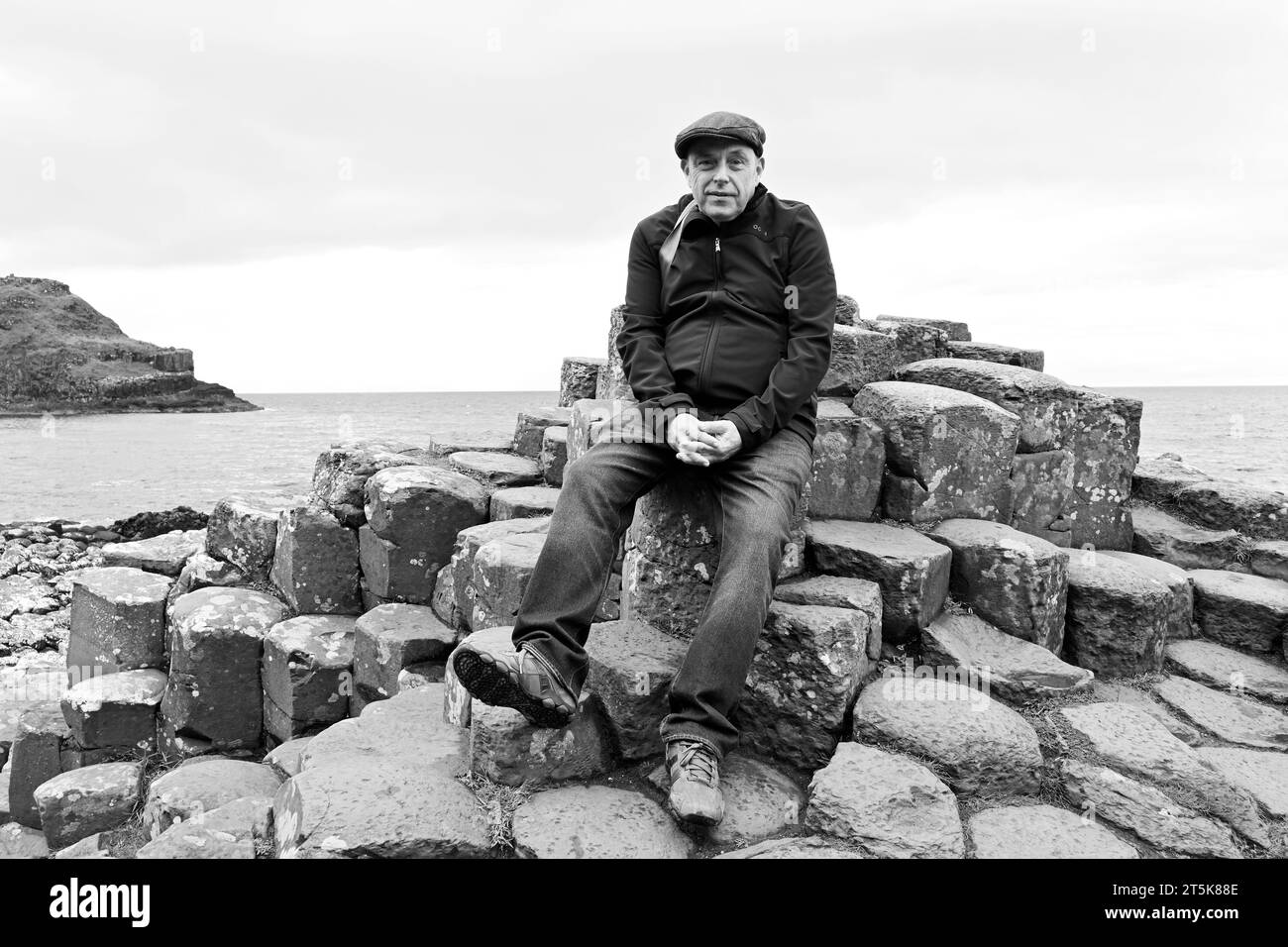 Portrait d'un homme assis sur les rochers à la chaussée des géants en Irlande du Nord Banque D'Images