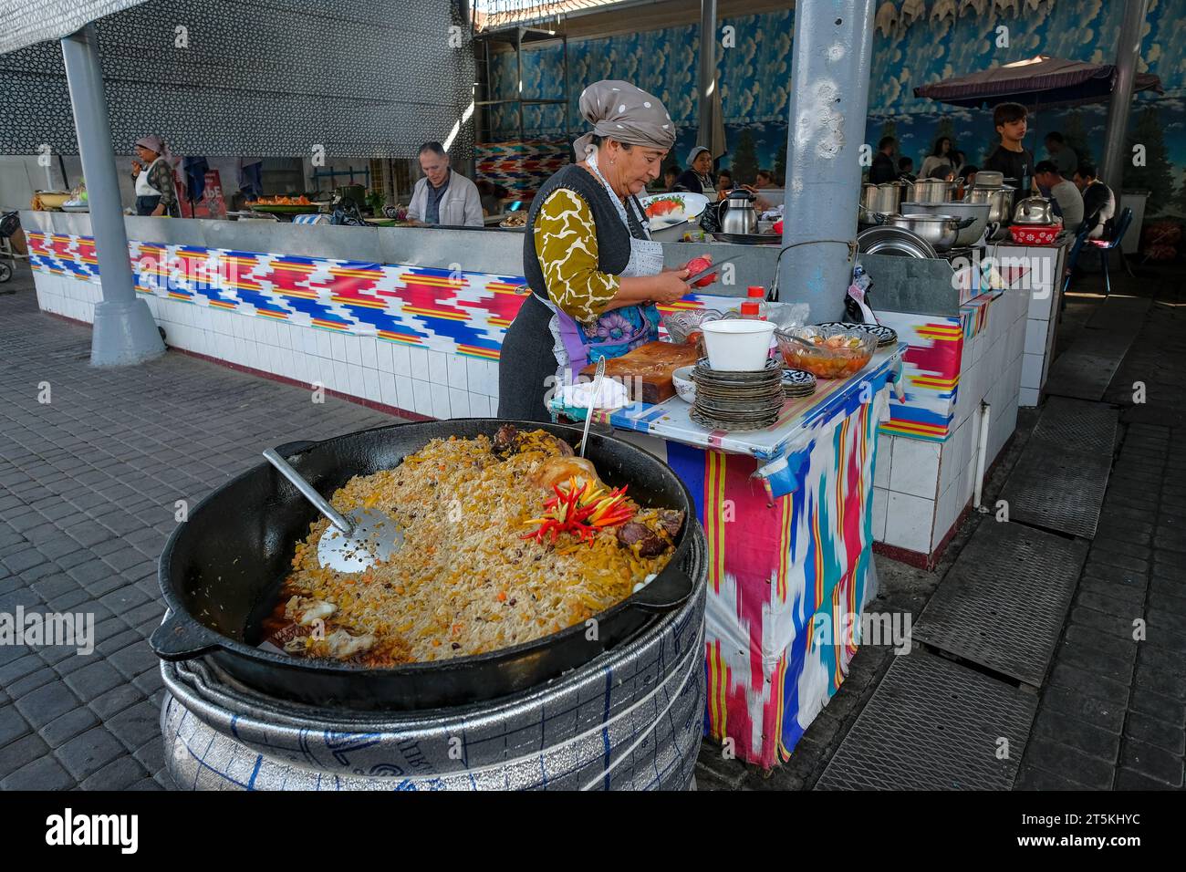 Tachkent, Ouzbékistan - 29 octobre 2023 : une femme cuisinant du riz au Chorsu Bazaar à Tachkent, Ouzbékistan. Banque D'Images