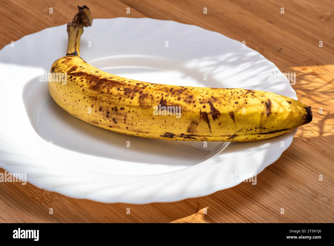 Banane mûre sur une assiette blanche Banque D'Images