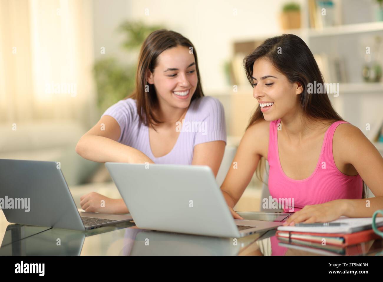 Deux étudiants heureux e-learning avec des ordinateurs portables à la maison Banque D'Images