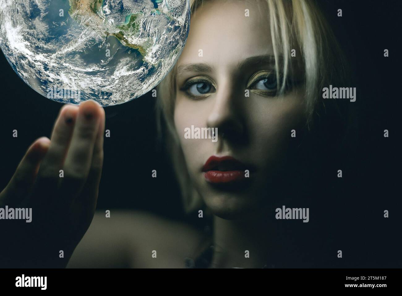 La femme tient la Terre dans sa main. Éléments de cette image fournis par la NASA Banque D'Images