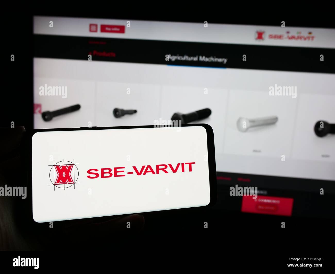 Personne tenant le téléphone portable avec le logo de la société italienne de fixation mécanique SBE-VARVIT spa en face de la page Web de l'entreprise. Concentrez-vous sur l'affichage du téléphone. Banque D'Images