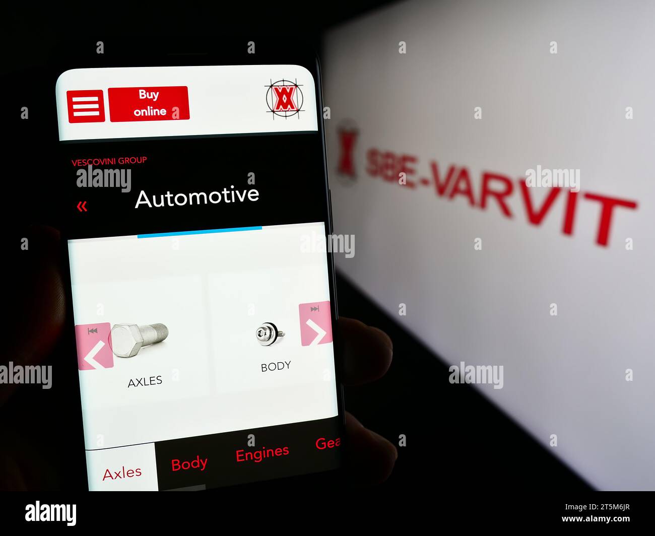 Personne détenant un téléphone portable avec une page web de la société italienne de fixation mécanique SBE-VARVIT S.p.A. avec logo. Concentrez-vous sur le centre de l'écran du téléphone. Banque D'Images