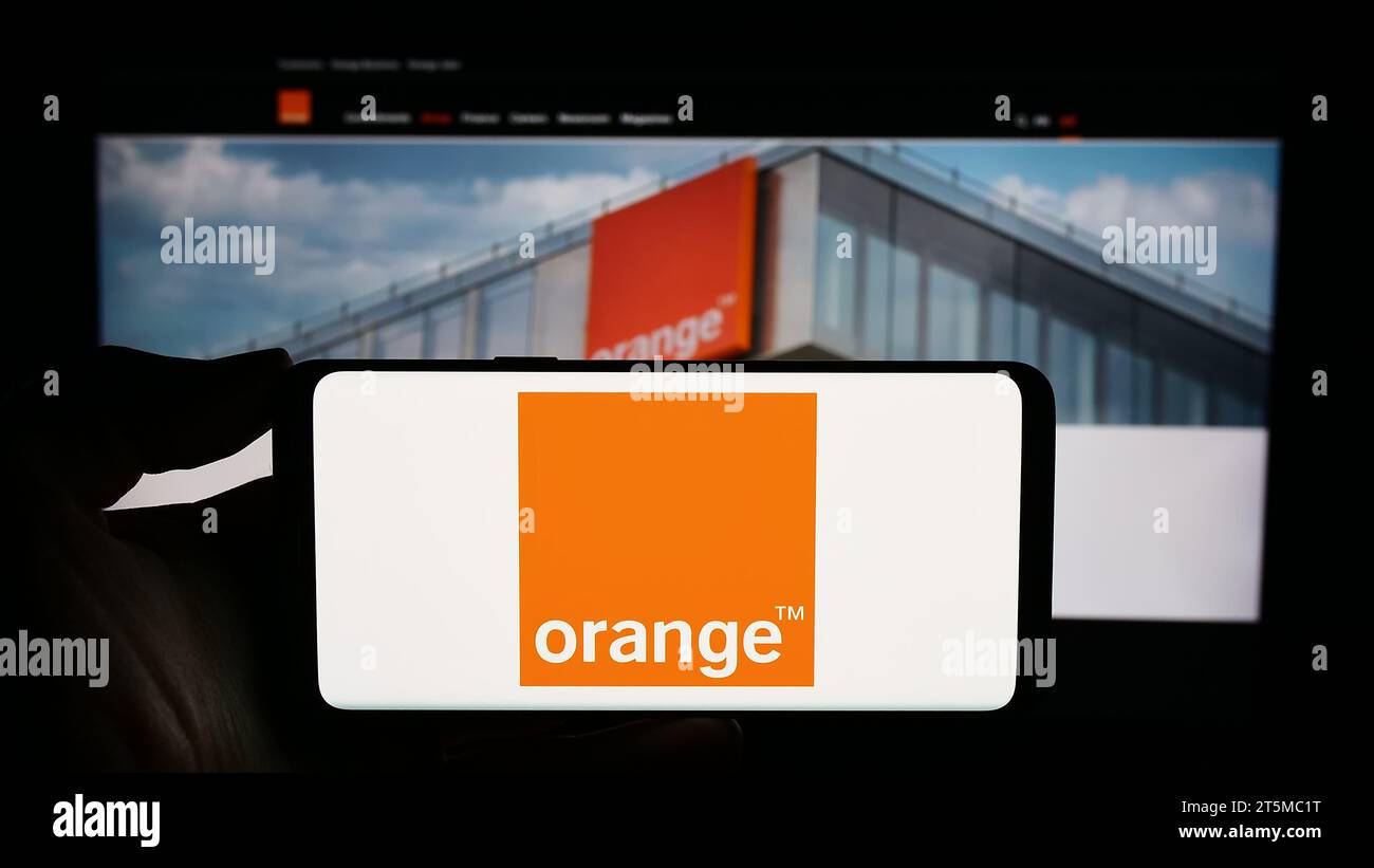 Personne détenant un smartphone avec le logo de la société française de télécommunications Orange S.A. devant le site Web. Concentrez-vous sur l'affichage du téléphone. Banque D'Images