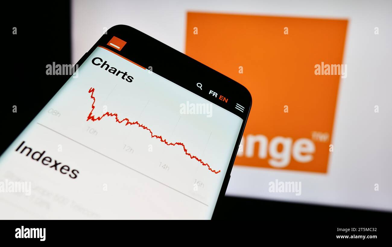 Smartphone avec le site Internet de la société française de télécommunications Orange S.A. devant le logo de l'entreprise. Effectuez le focus sur le coin supérieur gauche de l'écran du téléphone. Banque D'Images
