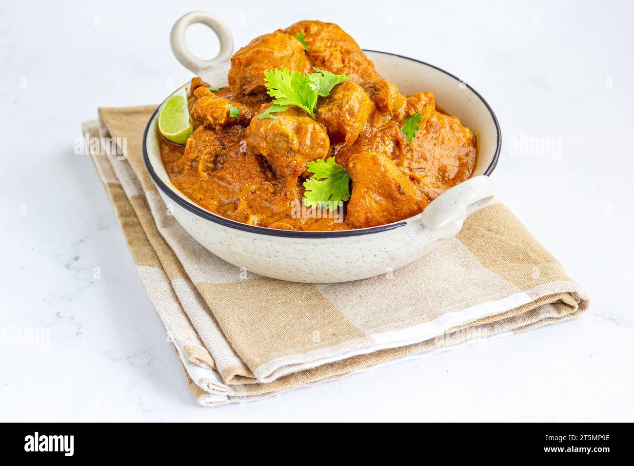 Curry de poulet indien à base de pâte de noix de cajou garnie de citron et de coriandre Banque D'Images