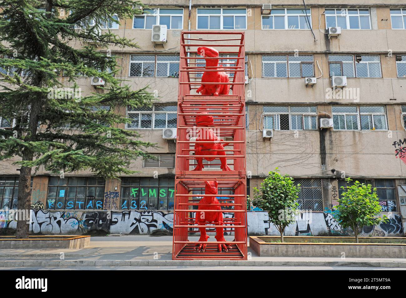 Sculptures de dinosaures rouges dans des cages Banque D'Images