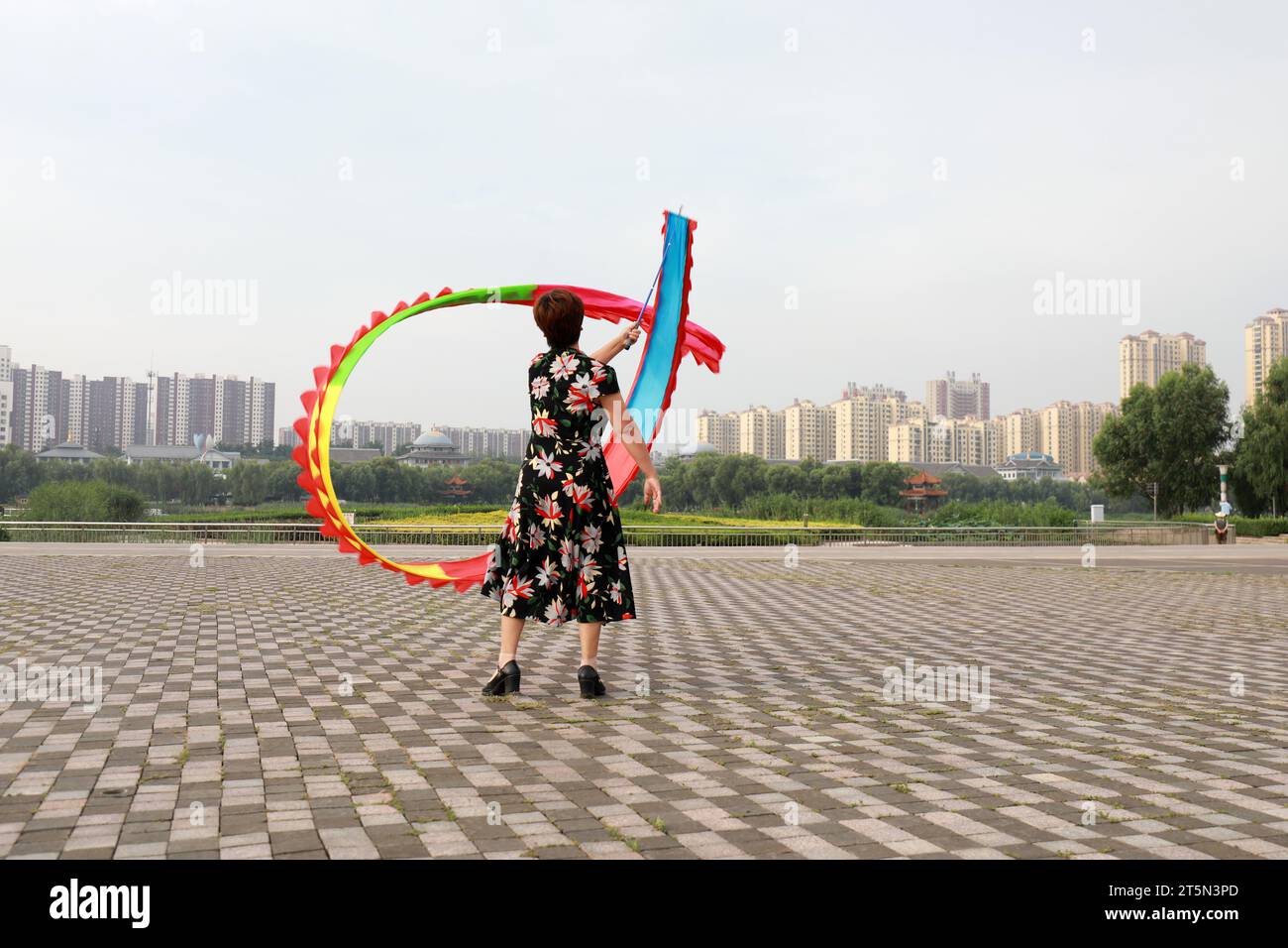 Les gens agitent la forme physique de soie colorée dans le parc, comté de Luannan, province du Hebei, Chine Banque D'Images