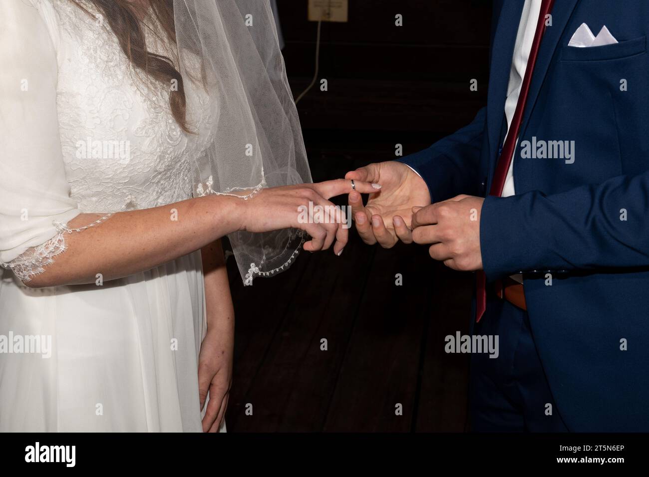 Une mariée tend la main et le doigt pour recevoir la bague achetée par le marié lors d'une cérémonie de mariage juif. Banque D'Images