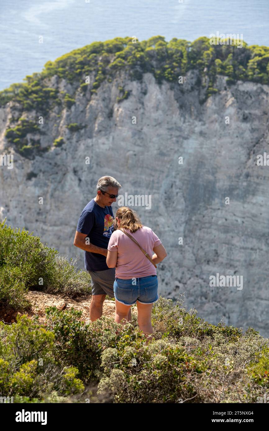 couple plus âgé d'âge moyen en vacances ensemble debout sur la falaise côtière sur l'île grecque de zante ou zakynthos en grèce. Banque D'Images