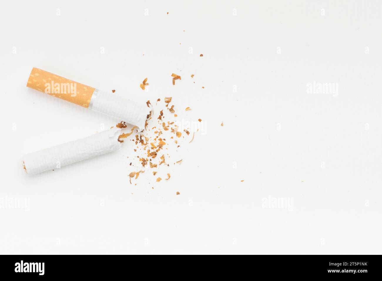 Tabac provenant de cigarettes cassées sur fond blanc Banque D'Images